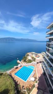 een uitzicht over een zwembad naast de oceaan bij Sea Front Apartment in Vlorë