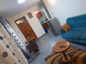 a living room with a blue couch and a table at Ella Apartment Namirembe Road in Kampala