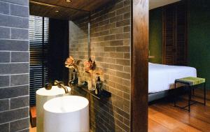 a bathroom with a sink and a bed in a room at Na Tanao 1969 in Bangkok