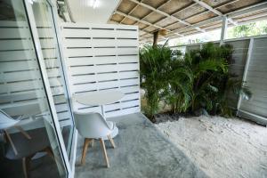 un patio con tavolo, sedie e piante di Oh'lala Studios a Baan Tai