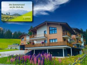 a building with flowers in front of it at Moderne Kaminstube in Ramsau am Dachstein