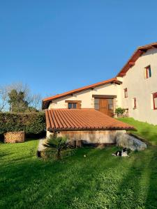 a house with a dog laying in the yard at Bidegurutzeta landetxea in Urnieta