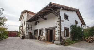 a white building with a gambrel roof at Bidegurutzeta landetxea in Urnieta