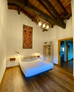 a bedroom with a large bed and wooden floors at Bidegurutzeta landetxea in Urnieta