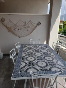 einen Esstisch mit Stühlen und einem Teppich an der Wand in der Unterkunft B&B Green House in Villapiana