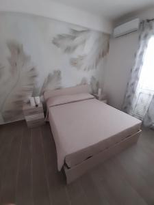 ein weißes Schlafzimmer mit einem Bett und einem Fenster in der Unterkunft B&B Green House in Villapiana