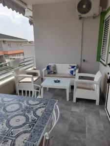 einen Balkon mit einem Tisch, Stühlen und einem Sofa in der Unterkunft B&B Green House in Villapiana
