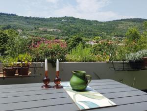 Una mesa con dos velas y un jarrón verde. en Relax fra le colline di Verona, en Verona
