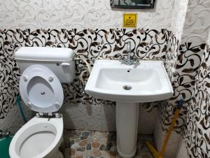 uma casa de banho com um WC e um lavatório em Aman Inn em Dharamshala