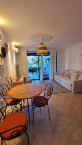 a living room with a table and chairs and a couch at Oasis Resort Apartment, Луксозен Апартамент в комплекс ОАЗИС in Lozenets