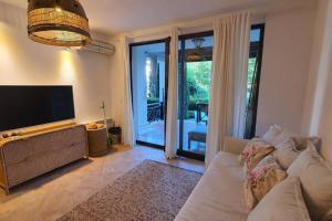 a living room with a couch and a flat screen tv at Oasis Resort Apartment, Луксозен Апартамент в комплекс ОАЗИС in Lozenets
