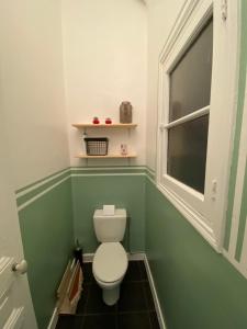 a small bathroom with a toilet and a window at Appartement Proche plages - Parking gratuit in Menton