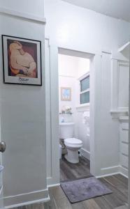 uma casa de banho com WC e uma fotografia na parede em Metro Paris - 3 Day Minimum - Secluded Studio near the Long Beach Harbor em Long Beach