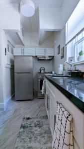 a kitchen with a refrigerator and a sink and a stove at Metro Paris - 3 Day Minimum - Secluded Studio near the Long Beach Harbor in Long Beach