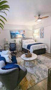 a bedroom with two beds and a couch and a table at Metro Paris - 3 Day Minimum - Secluded Studio near the Long Beach Harbor in Long Beach
