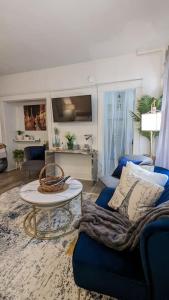 a living room with a blue couch and a table at Metro Paris - 3 Day Minimum - Secluded Studio near the Long Beach Harbor in Long Beach