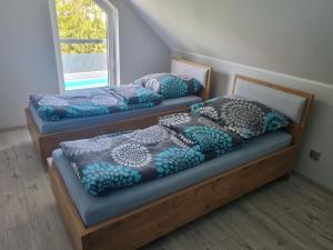 2 łóżka pojedyncze w pokoju z oknem w obiekcie Villa Lipowe Wzgórze w mieście Narty