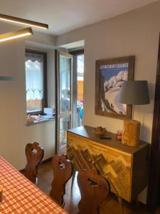 una sala da pranzo con tavolo, sedie, tavolo e finestra di Les Arnauds a Bardonecchia