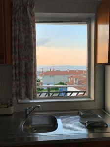 um lavatório de cozinha com vista para uma janela em John Baker's Apartments em Polykhrono