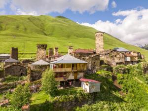 an old building with two towers on a hill at GuestHouse NaSHGOBI in Ushguli
