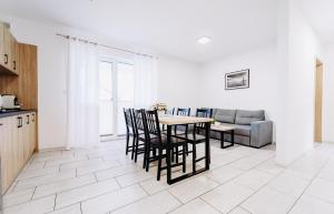 een woonkamer met een tafel en stoelen en een bank bij Nadmorska Przystan - Apartamenty caloroczne in Ustka