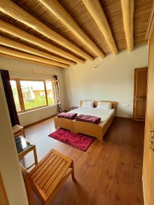 um quarto com uma cama e um tecto de madeira em Chakzot garden house em Leh