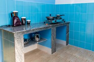 a counter in a room with blue tiles at Panism Lifestyle in Auroville