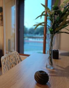 ein Holztisch mit einer Vase mit Blumen darauf in der Unterkunft Paris & Disney - LES BORDS DE MARNE in Meaux