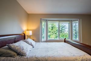 a bedroom with a bed and two windows at First Estate Winery in Peachland