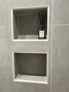 a shelf in a bathroom with a bottle in it at JV Athens in Athens