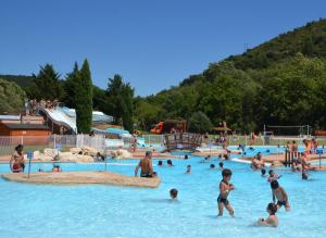 a group of people in a pool at a water park at Le Mas du figuier, Maison de vacances in Le Bousquet-dʼOrb
