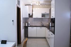 a kitchen with white cabinets and a sink at Kod Mladena in Buković