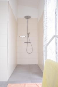y baño con ducha con paredes blancas. en Schöne Deluxe Unterkunft, en Gottmadingen