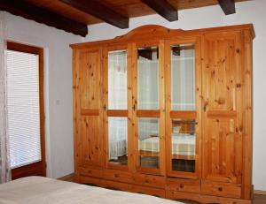 a wooden cabinet with glass doors in a bedroom at SARAJEVO HOME in Sarajevo