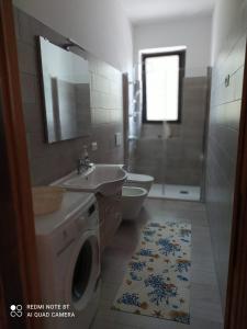 y baño con lavadora y lavamanos. en La casa di Fofo' e Ninetta, en San Vito Chietino