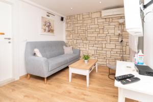 ein Wohnzimmer mit einer Couch und einer Ziegelwand in der Unterkunft Apartment Cameleon in Dubrovnik
