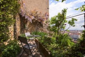 una mesa y una silla sentadas en un lateral de un edificio en Les jardins du Gourguillon en Lyon