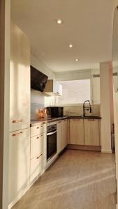 Una cocina con gabinetes blancos y un horno de estufa. en Aux portes de Paris / Studio Bord de Marne, en Bry-sur-Marne