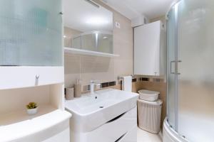 ein weißes Badezimmer mit Waschbecken und Dusche in der Unterkunft Apartment Cameleon in Dubrovnik + 37 Fotos