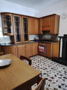 Casal Sottano的住宿－Delizioso appartamento al centro di Bosco SAN GIOVANNI A PIRO，厨房配有木制橱柜和木桌。