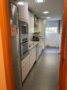 a kitchen with stainless steel appliances and a tile floor at XRYHOMES I Residencial en Jerez 4 hab, 2 baños, 7pax, 10 min del centro in Jerez de la Frontera