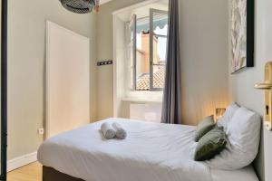 een slaapkamer met een bed met twee handdoeken erop bij Les jardins du Gourguillon in Lyon