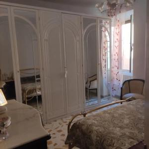 Casal Sottano的住宿－Delizioso appartamento al centro di Bosco SAN GIOVANNI A PIRO，一间卧室配有一张床和一面大镜子
