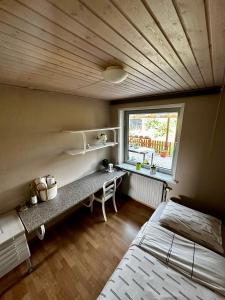 1 dormitorio con cama, escritorio y ventana en OJ Home, en Vojens