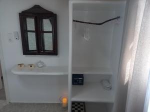 a white bathroom with a sink and a window at Νύμφη in Kimolos