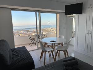 a living room with a table and chairs and a view of the ocean at Suites Alicante in Alicante