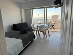 a bedroom with a bed and a table and a balcony at Suites Alicante in Alicante