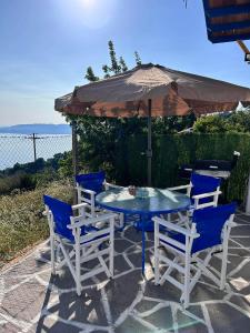 un tavolo e sedie con ombrellone su un patio di Avgoustina's Home a Glossa