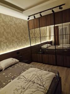 a bedroom with two beds and a mirror at MB Apartments in Jagodina