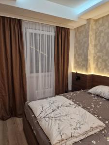 a bedroom with a bed and a window at MB Apartments in Jagodina
